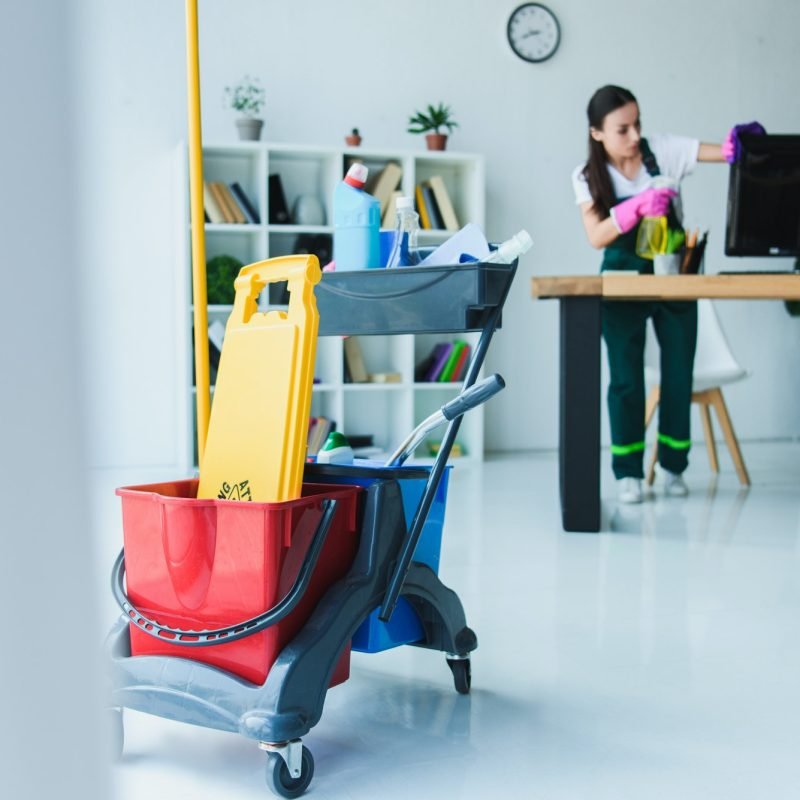 young female janitor cleaning office with various cleaning equipment young female janitor cleaning office with various cleaning equipment